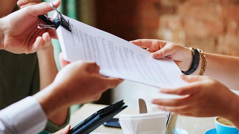 Lawyer handing over legal document at  a meeting in a cafe